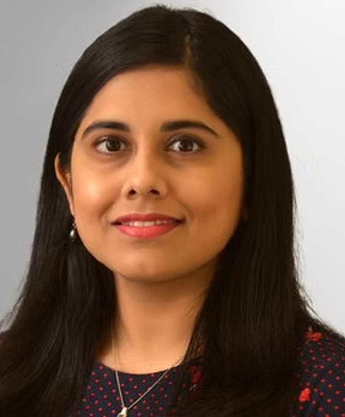 Woman with long black hair and polka dot dress.