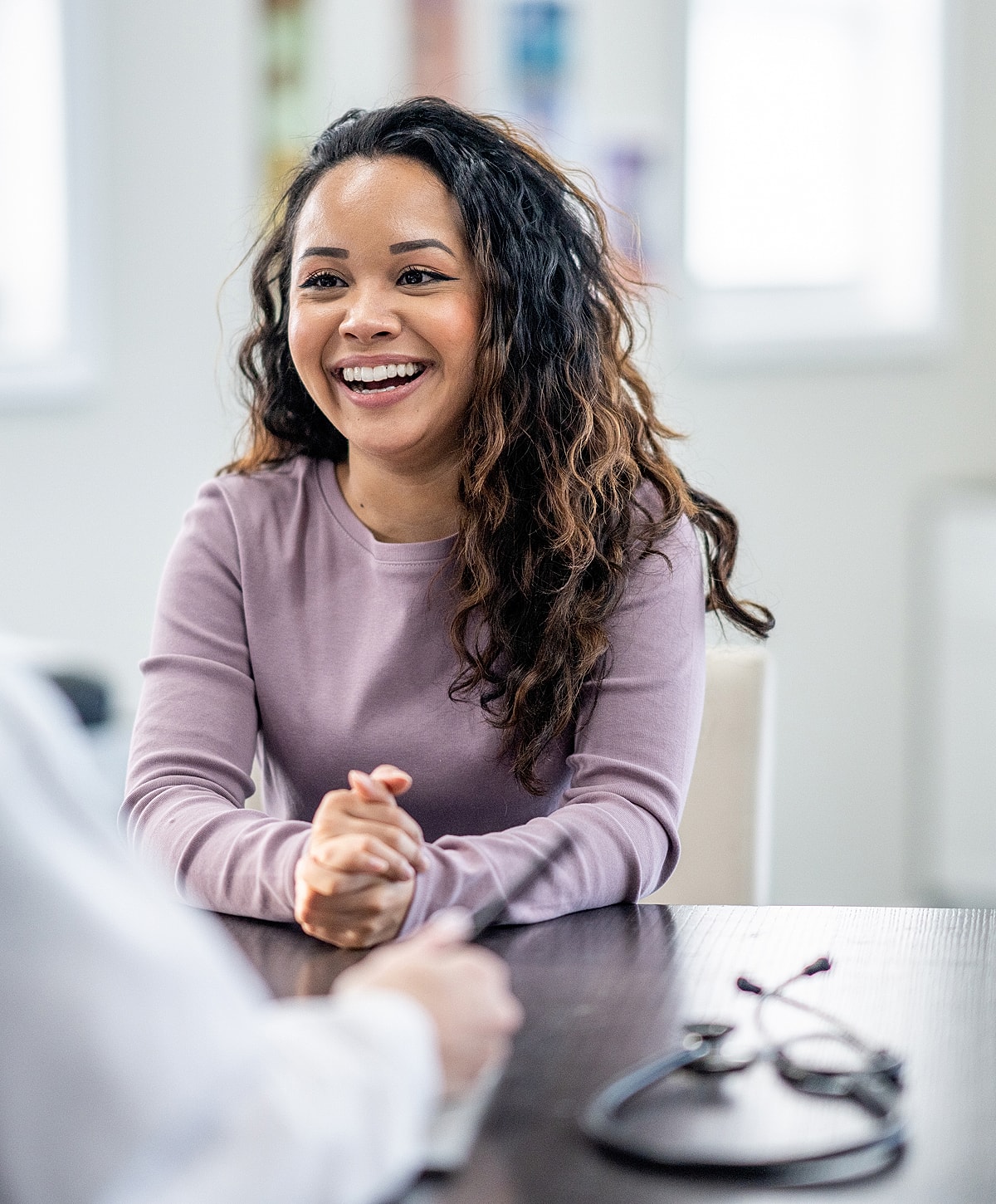 Smiling woman in a consultation setting.