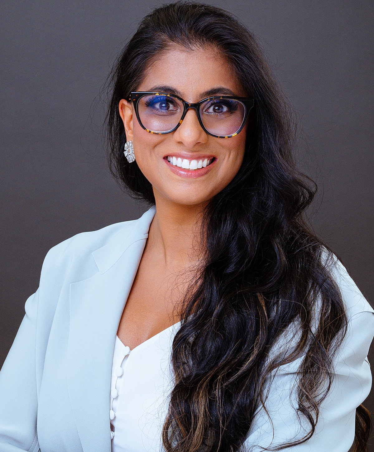Professional woman smiling with long dark hair.
