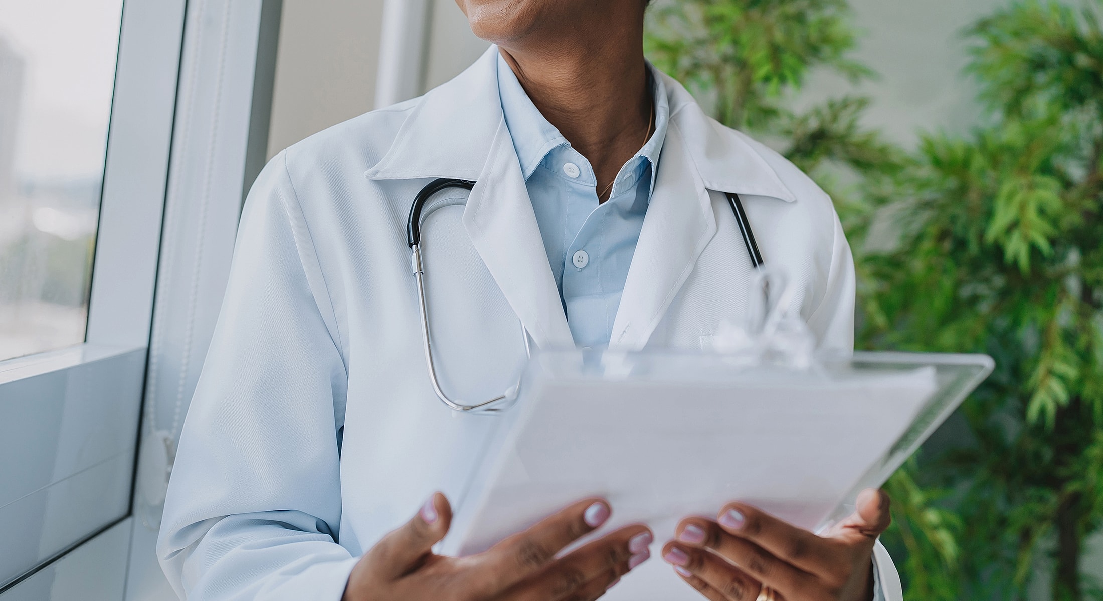Healthcare professional with clipboard and stethoscope.
